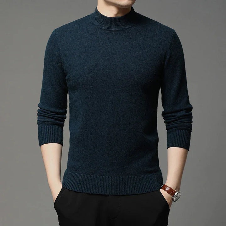 Man wearing a dark navy blue ribbed mock neck sweater with long sleeves and black pants