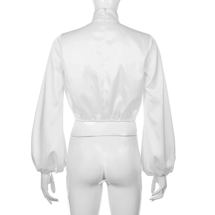 Back view of white long sleeve crop top with elastic waist and puffed sleeves on mannequin