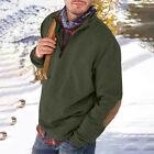 Man wearing olive green pullover with elbow patches and carrying a backpack in snowy outdoor setting