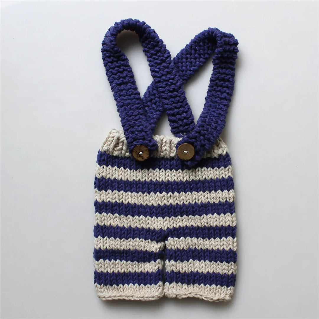 Handmade knitted baby romper with navy blue and cream stripes and buttoned suspenders