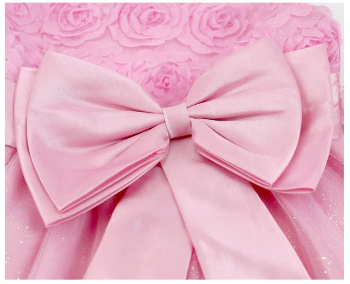 Close-up of a pink satin bow on a textured floral pink fabric background