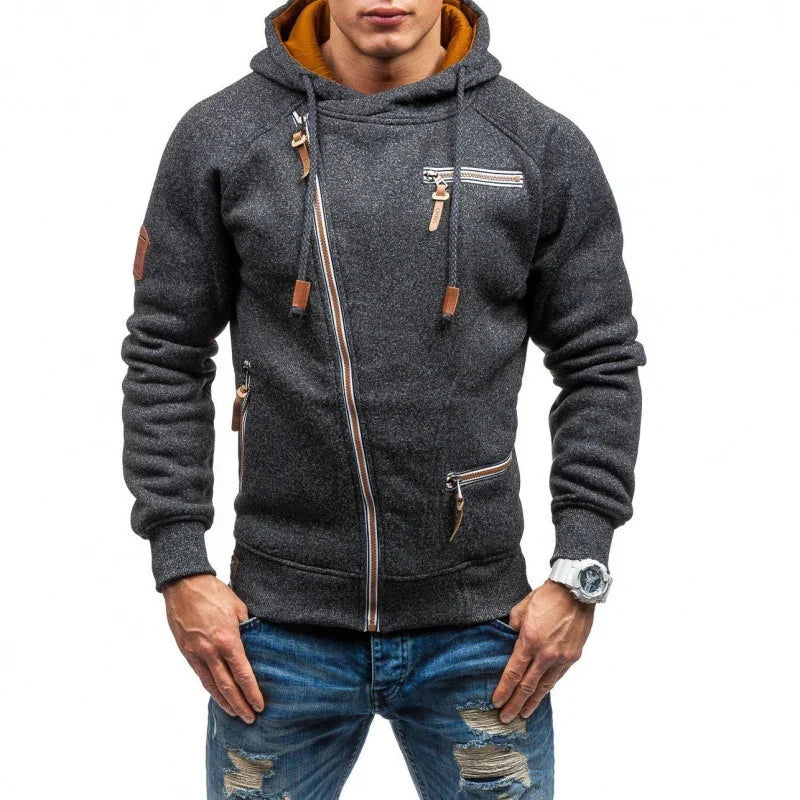 Man wearing dark gray asymmetrical zip hoodie with brown accents and ripped blue jeans
