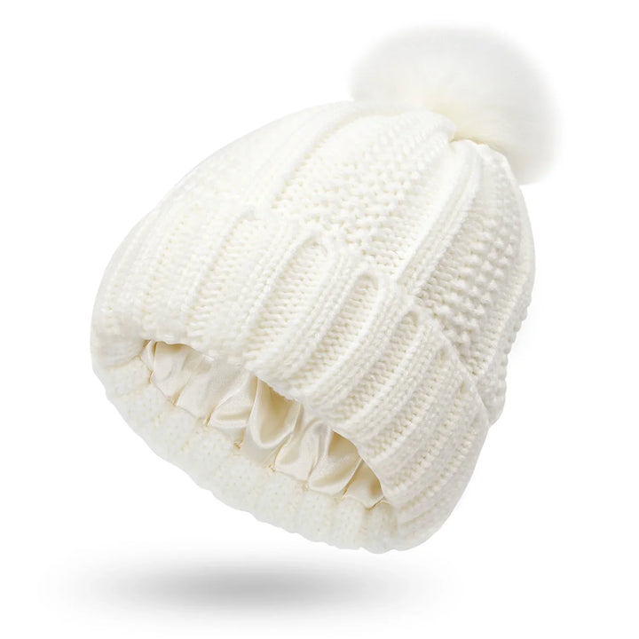 White knitted winter beanie with a fluffy pom pom and satin-lined interior
