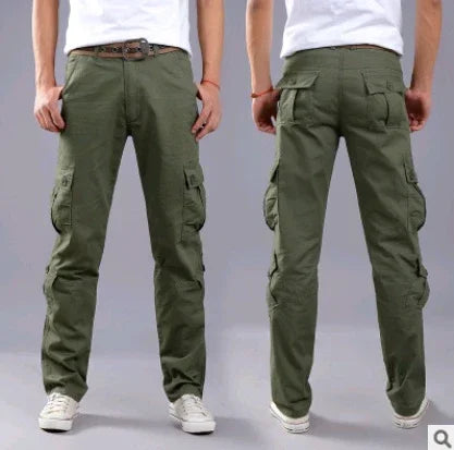 Front and back view of man wearing olive green cargo pants with multiple pockets and white sneakers