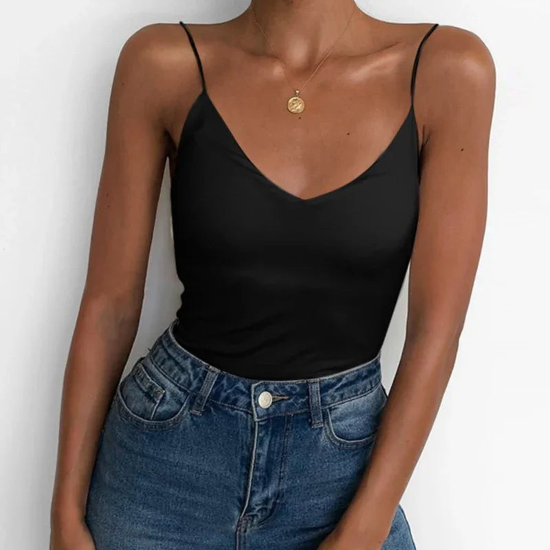 woman wearing black spaghetti strap tank top tucked into high-waisted blue jeans with gold pendant necklace