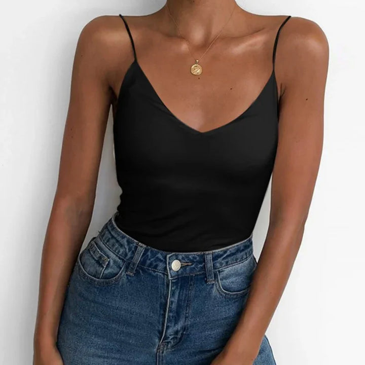 woman wearing black spaghetti strap tank top tucked into high-waisted blue jeans with gold pendant necklace