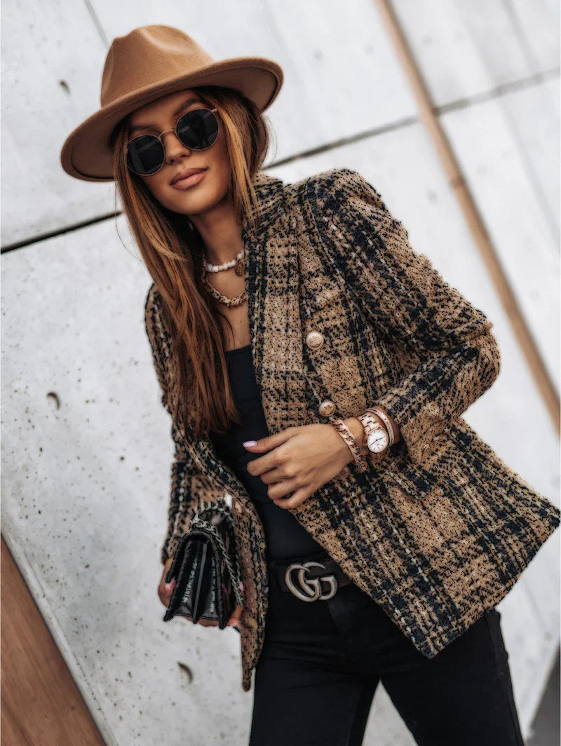 Stylish woman in brown hat, plaid blazer, sunglasses, black top, and Gucci belt holding a black handbag