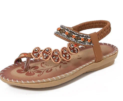brown leather thong sandal with decorative beads and floral design on insole