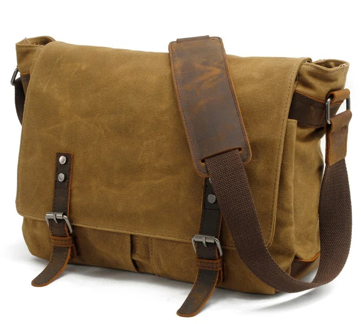 Brown canvas messenger bag with leather straps and adjustable shoulder pad