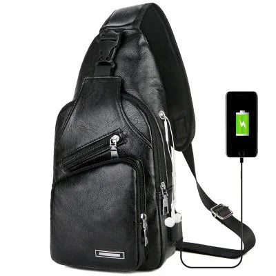 Black leather sling backpack with multiple zippered pockets and USB charging cable connecting to a smartphone