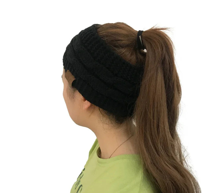 Woman with long brown ponytail wearing a black knit headband and green shirt, side view