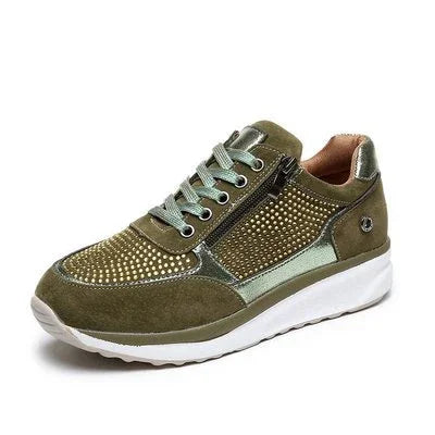 olive green suede sneaker with gold studs, light green accents, side zipper, and white sole