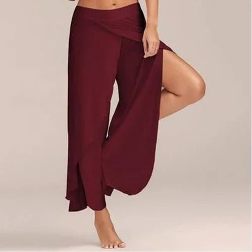 Woman wearing burgundy wrap pants with side slit and bare feet on beige background