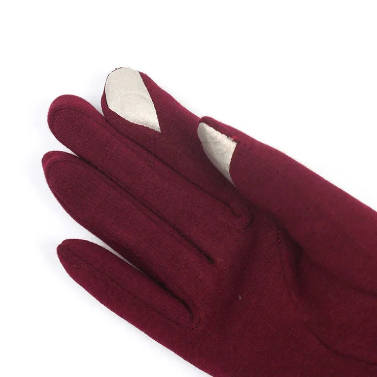 Close-up of maroon gloves with white touchscreen-compatible fingertips on a white background