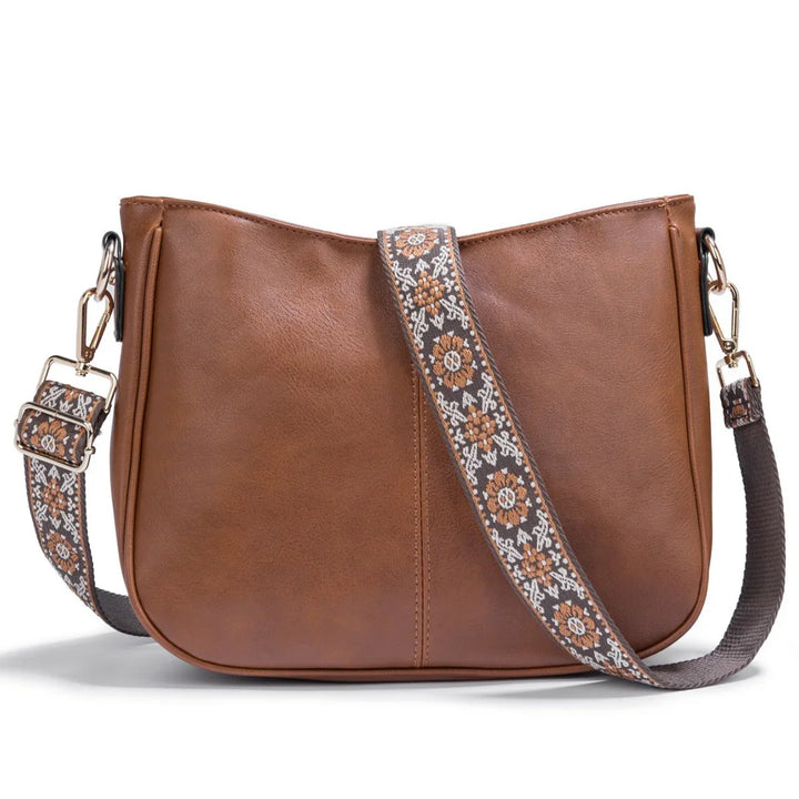 Brown leather crossbody bag with floral patterned adjustable strap and gold hardware
