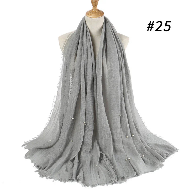 Light gray soft scarf with pearl embellishments displayed on a mannequin bust