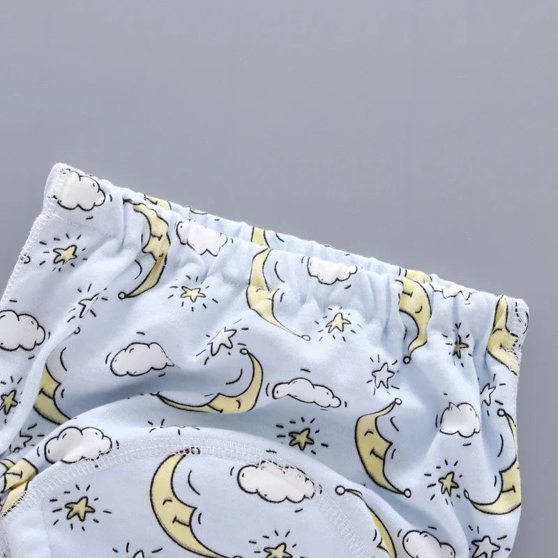 Light blue toddler underwear with moon, cloud, and star pattern on gray background