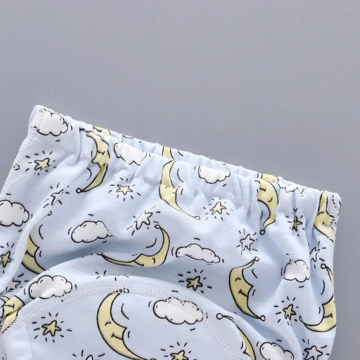 Light blue toddler underwear with moon, cloud, and star pattern on gray background