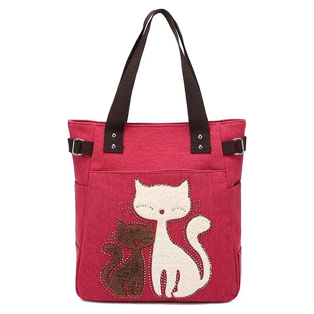 Red tote bag with brown handles featuring cute white and brown cat applique design