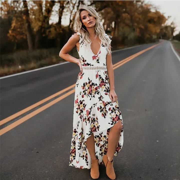 Woman in white floral dress with high-low hem standing on empty road in autumn setting