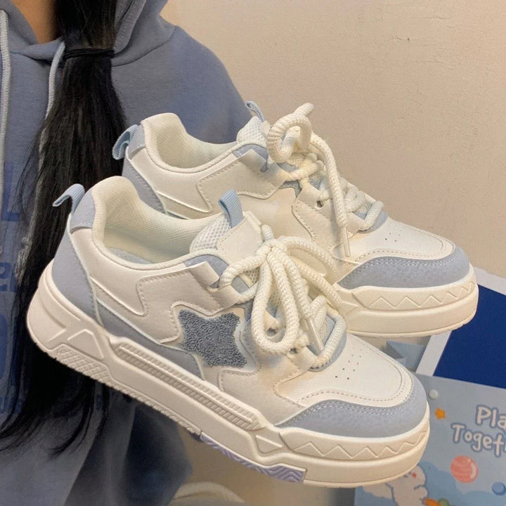 Close-up of white and light blue casual sneakers with star design on side and thick laces