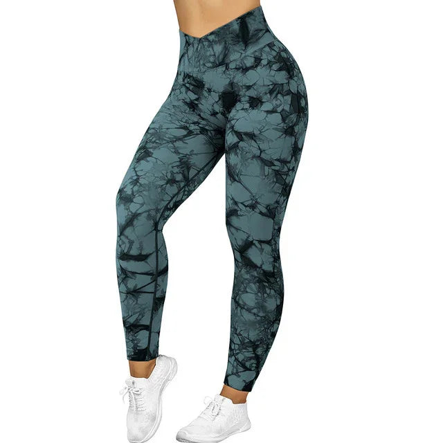 High-waisted blue and black tie-dye leggings on a model wearing white sneakers