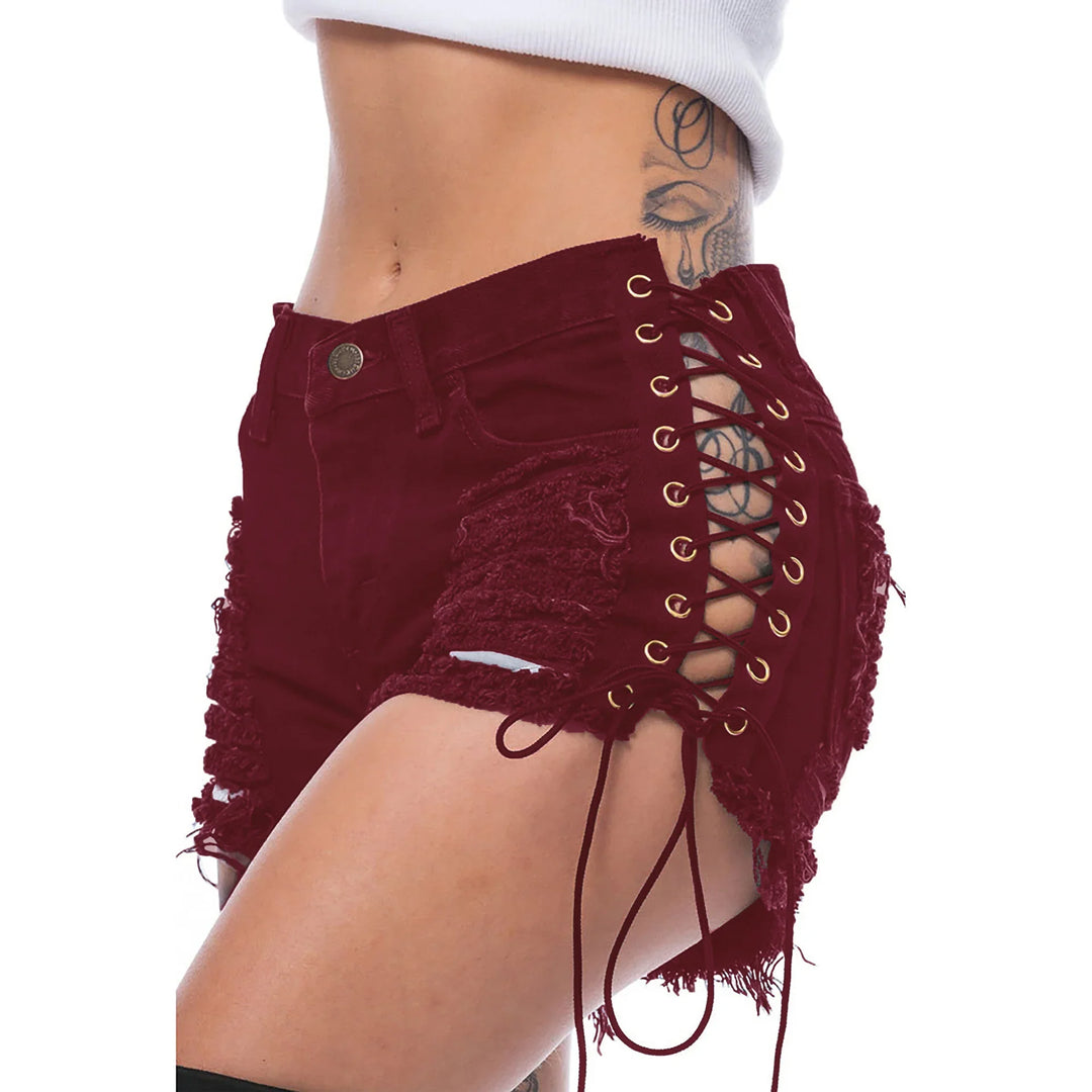 Close-up of woman wearing distressed burgundy lace-up denim shorts with side cutouts and tattoo on hip