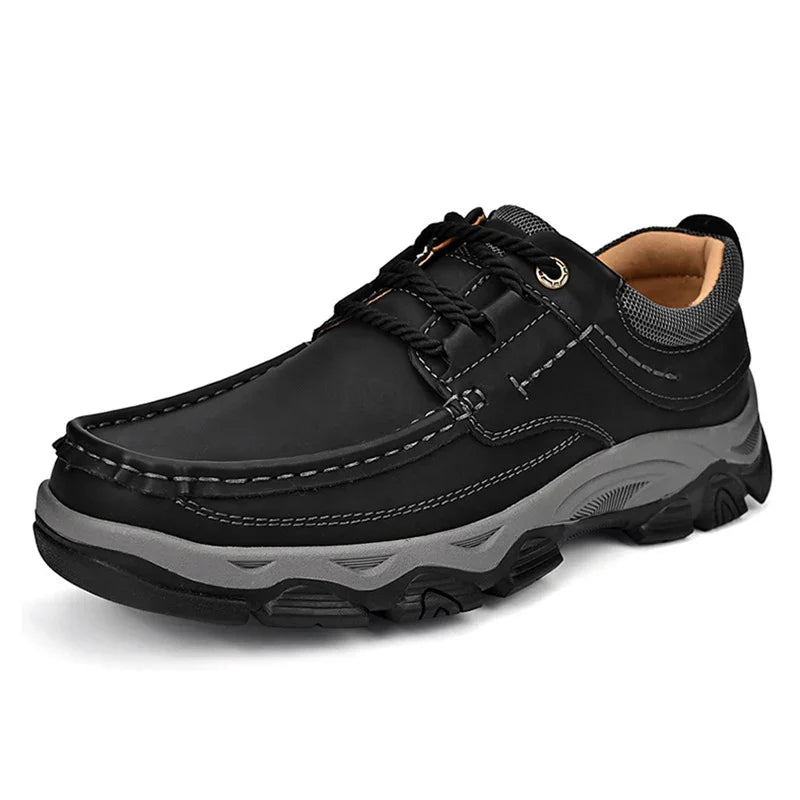 Black casual men's shoe with gray sole, stitched detailing, and padded collar on white background