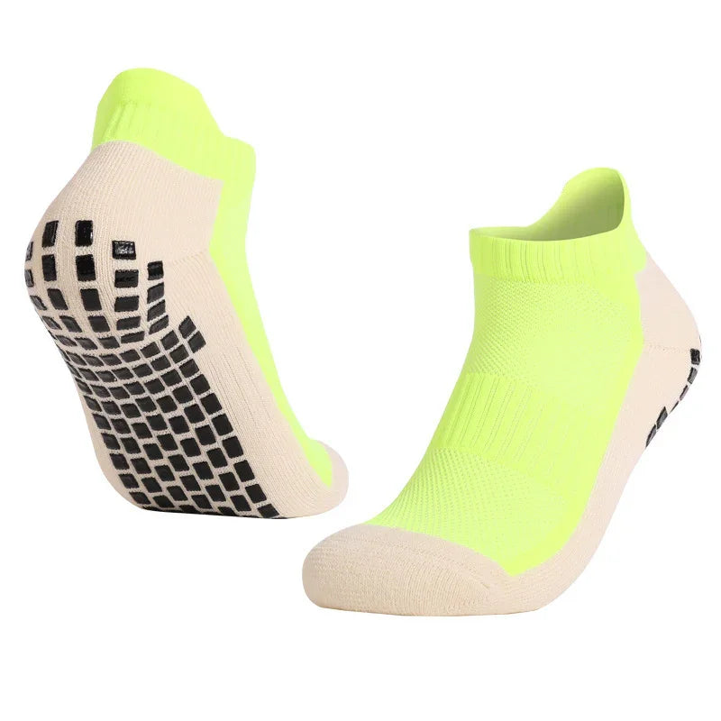 Pair of neon yellow and beige non-slip grip ankle socks with black rubberized sole dots