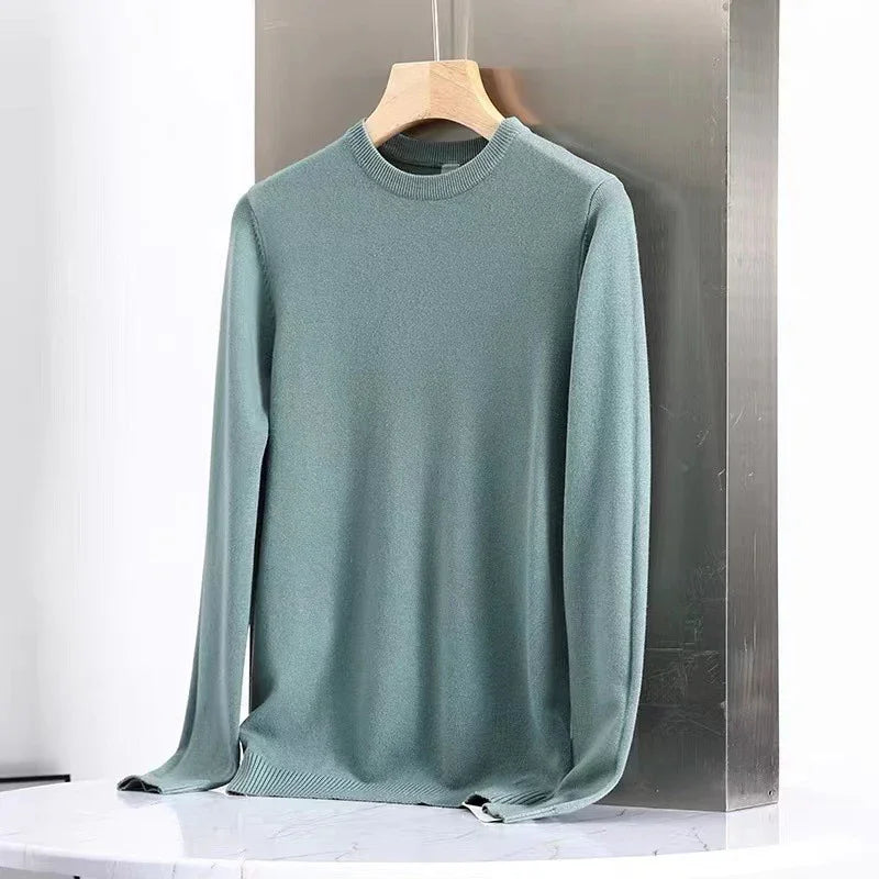 Light blue long-sleeve knit sweater on wooden hanger against metallic backdrop