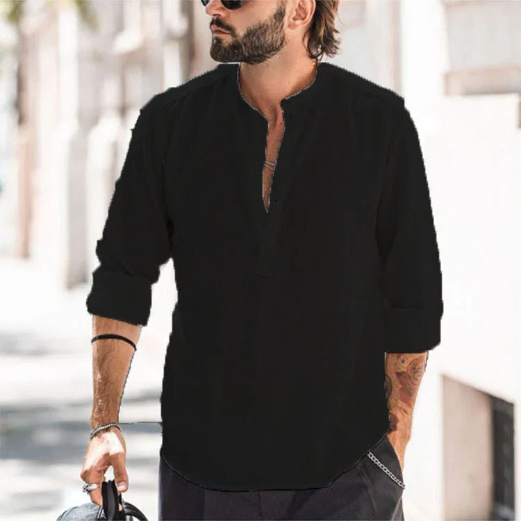 Bearded man wearing black casual shirt with rolled sleeves and sunglasses outdoors