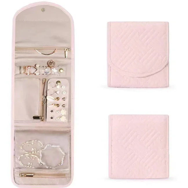 Pink quilted foldable jewelry organizer with compartments holding necklaces, earrings, and bracelets