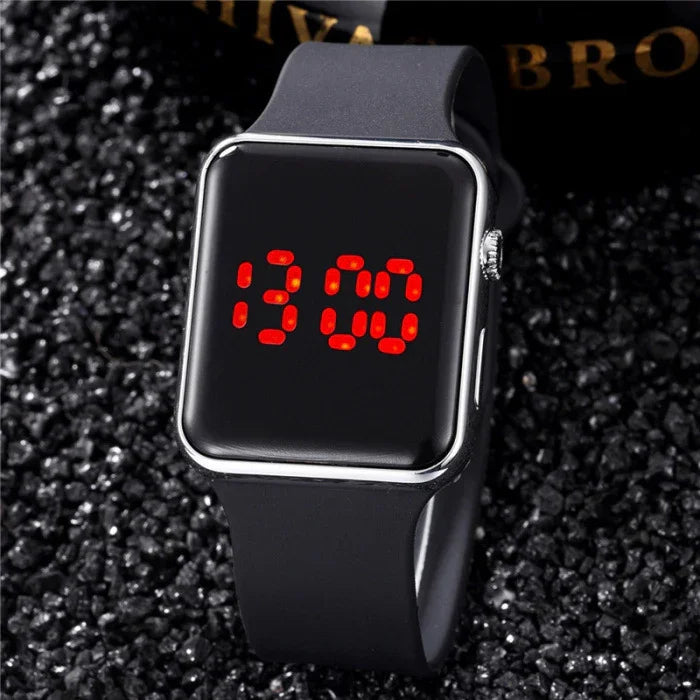 Modern black digital wristwatch with red LED display showing 13:00 on textured black surface