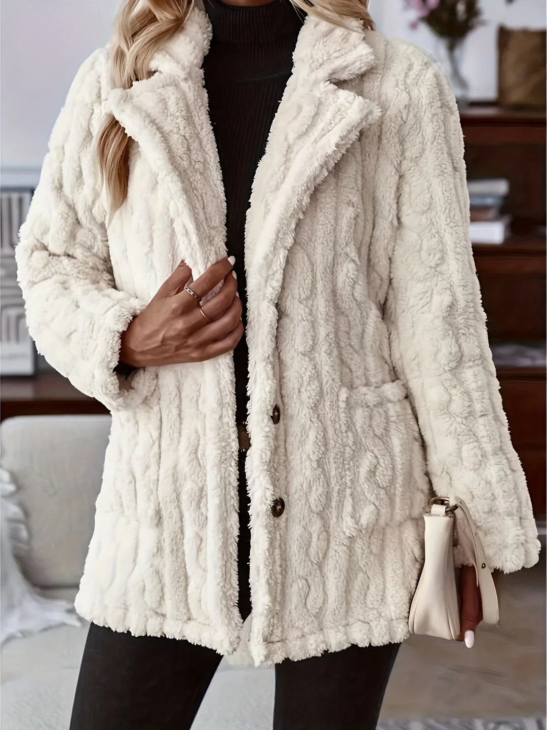 Woman wearing a cozy cream cable knit faux fur coat with front pockets and buttons