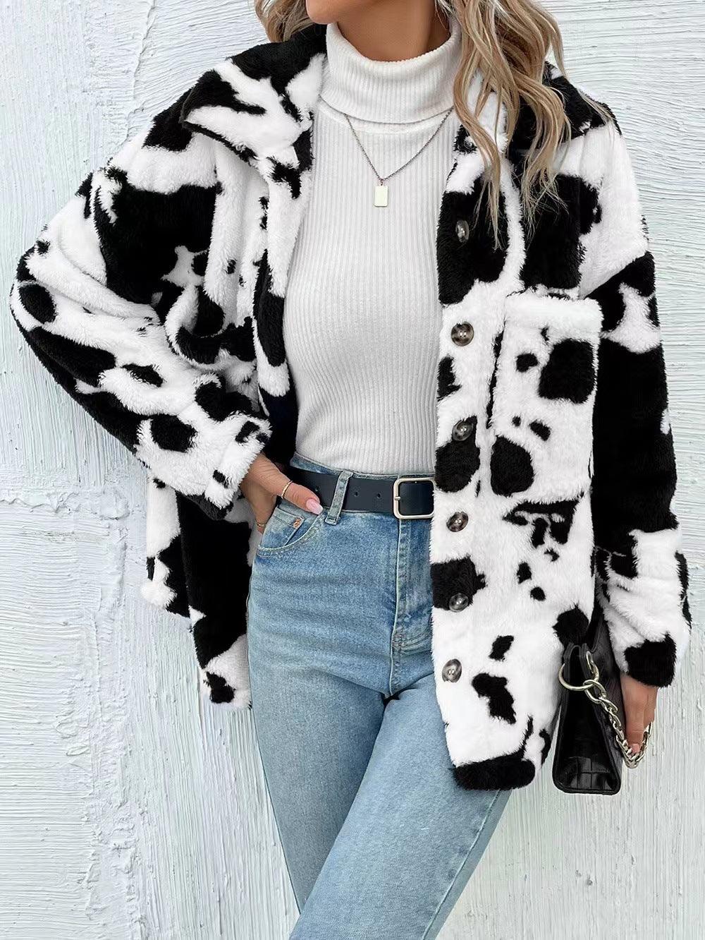 Woman wearing cow print faux fur jacket, white turtleneck sweater, light blue jeans, and black purse