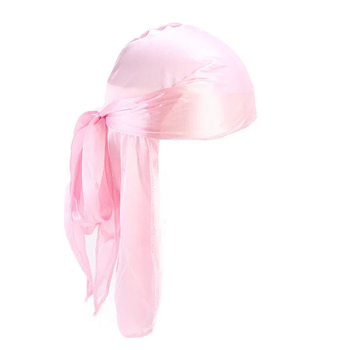 Soft pink satin durag with long tails tied in a knot against white background