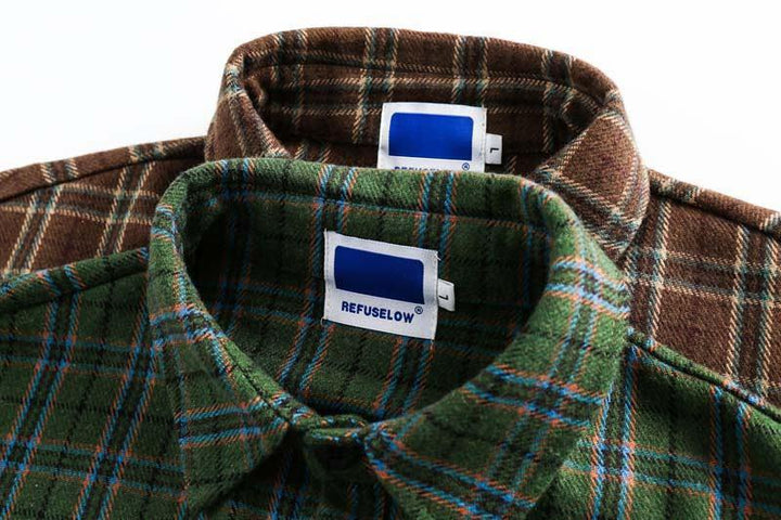 Close-up of green and brown plaid flannel shirts with REFUSELOW brand tags on collars