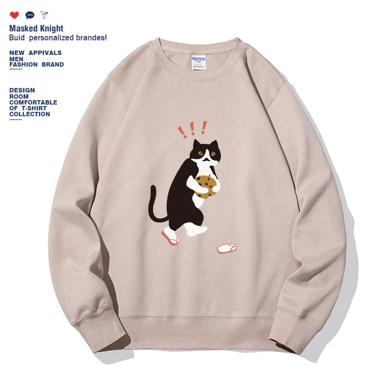 Beige sweatshirt featuring a black and white cat holding a cookie with surprised expression design
