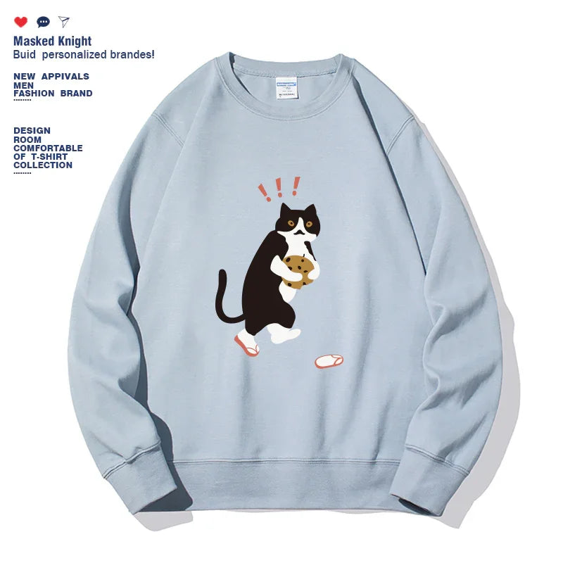 Light blue sweatshirt featuring a cartoon black and white cat holding a cookie with red exclamation marks above its head