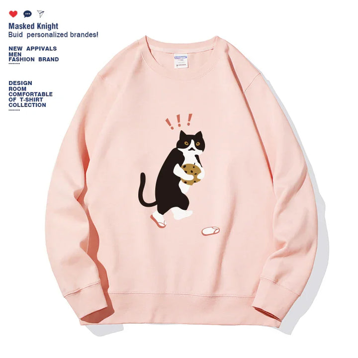 Pink sweatshirt with cartoon black and white cat holding a cookie and surprised expression graphic