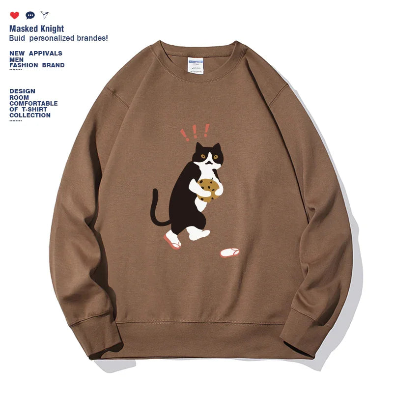 Brown sweatshirt featuring a surprised black and white cat holding a cookie graphic with text on left side