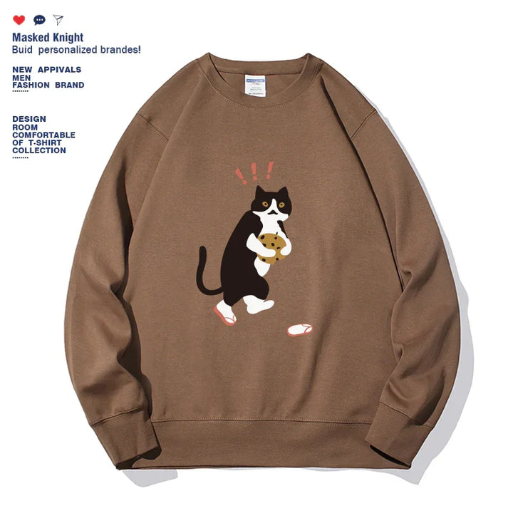 Brown sweatshirt featuring a surprised black and white cat holding a cookie graphic with text on left side
