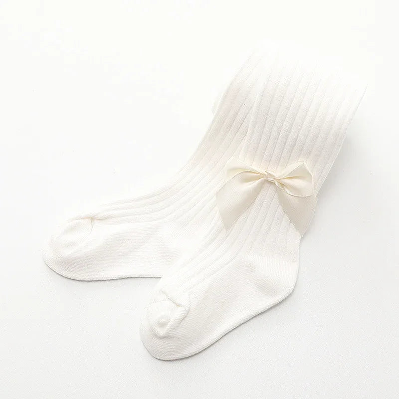 White ribbed baby tights with a small bow detail on a white background