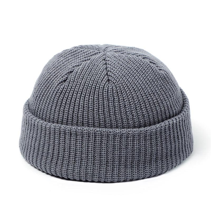 Gray knitted beanie hat with folded cuff on white background