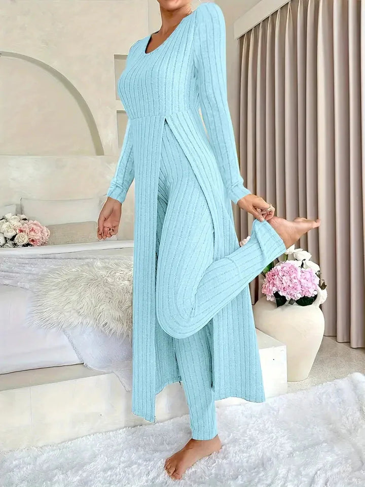 Woman in light blue ribbed knit loungewear set standing barefoot in cozy modern bedroom