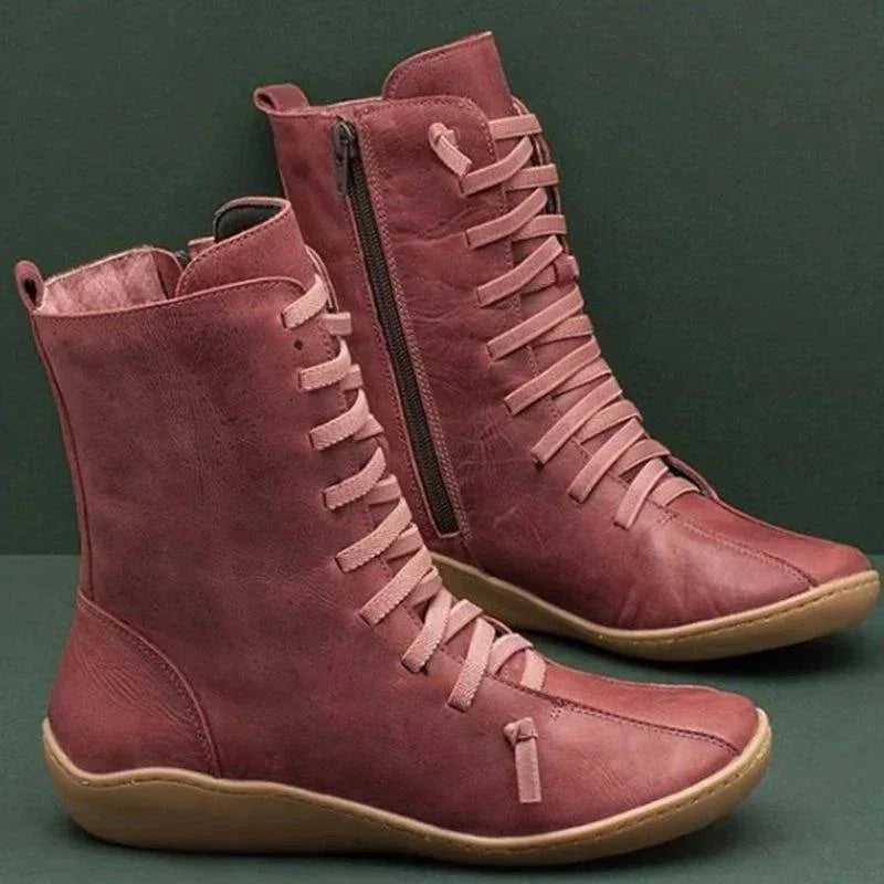 Pair of stylish dusty pink leather ankle boots with side zipper and flat rubber soles