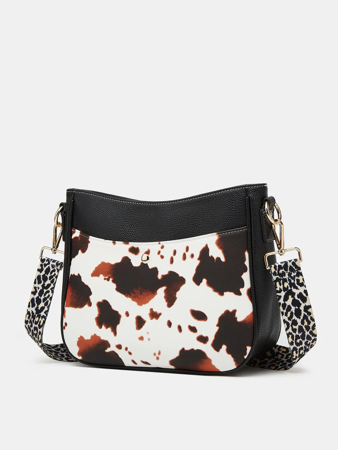 Black and white cow print crossbody bag with leopard print adjustable strap and gold hardware