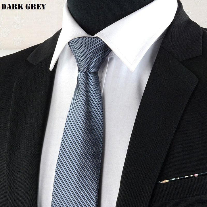 Close-up of dark grey striped necktie on white shirt with black suit jacket