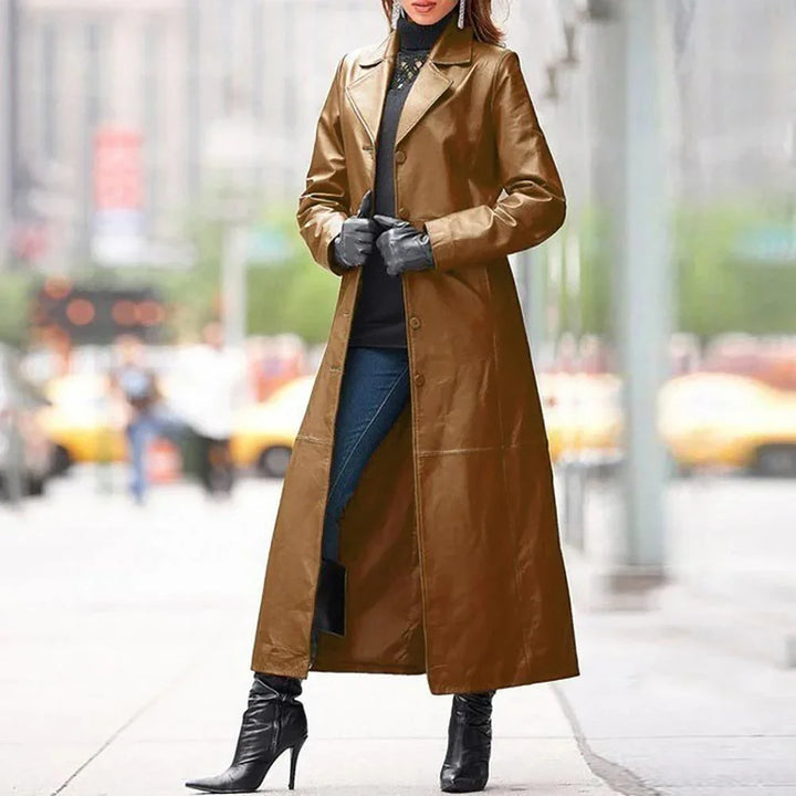 Woman wearing a long brown leather trench coat with black gloves and high-heeled boots on city street