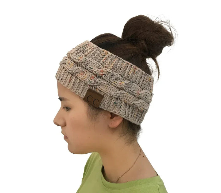 Side profile of woman wearing beige knit cable headband with ponytail and green top